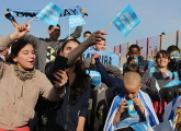 Jóvenes y niños atentos al partido